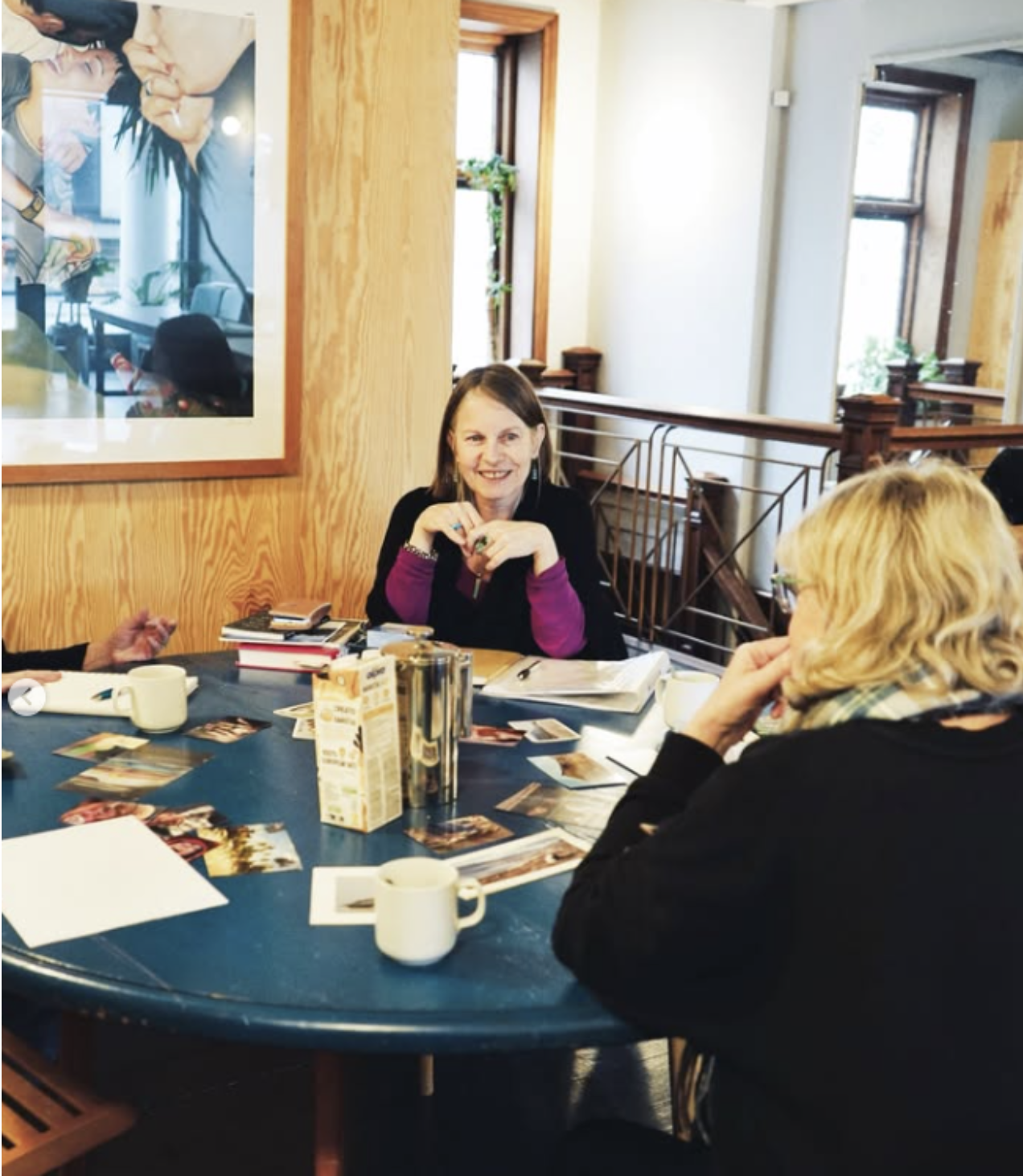 Nicky Torode facilitating a workshop around a table with photo cards